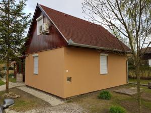 una casa gialla con tetto marrone di Boglárka Horgásznyaraló a Gyomaendrőd