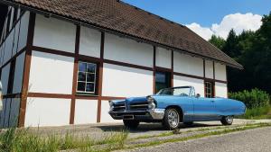 ein blaues Auto, das vor einem Gebäude parkt in der Unterkunft Vintage House am Faaker Seebach in Finkenstein