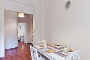 a white dining room with a white table and chairs at Liberty Trastevere B&B in Rome