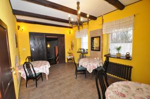 comedor con 2 mesas y sillas y paredes amarillas en Zajazd Wiejski, en Ozorzyce
