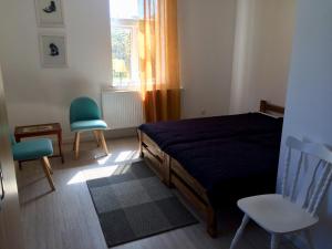 - une chambre avec un lit, deux chaises et une fenêtre dans l'établissement Dzikówka, à Dzików Stary