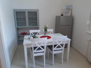 a white dining room table with white chairs and a refrigerator at Apartman Kod Kestena in Osijek +19 photos