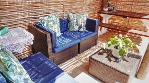 una silla de mimbre y una mesa en el patio en Inn-Style, en Ciudad del Cabo