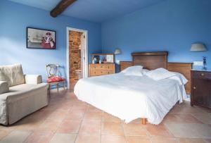 1 dormitorio con 1 cama, 1 sofá y paredes azules en Pazo Da Cruz, en Villarmayor