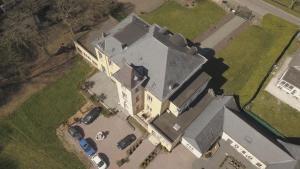 an aerial view of a large house with parked cars at Kasteel B&B Sint-Bartel in Geraardsbergen