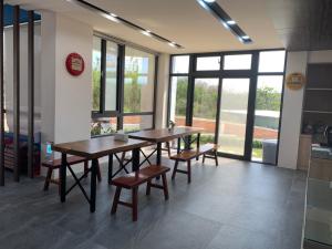 a dining room with two tables and chairs and windows at 綠水悠遊民宿 in Xiyu