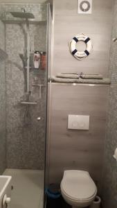 a bathroom with a toilet and a shower and a sink at WAW vakantie appartement in Westende