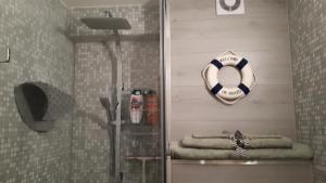 a bathroom with a shower with a lifebuoy and towels at WAW vakantie appartement in Middelkerke +28 photos