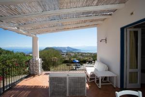 a patio with a table and chairs on a balcony at Rosa Dei Venti in Lipari