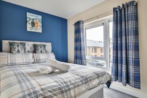 a bedroom with a bed with blue walls and a window at Beautiful City Centre House with Parking! Sleeps 6 in Sheffield