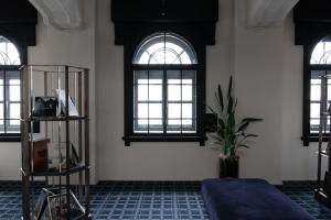 a room with three windows and a blue floor at HakoBA Hakodate by THE SHARE HOTELS in Hakodate