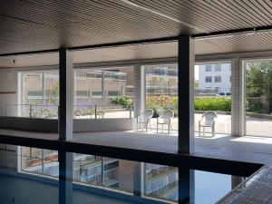 a group of chairs sitting on the balcony of a building at Appartement in residentie Silverbeach met binnenzwembad in De Haan