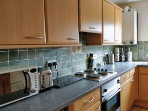 a kitchen with wooden cabinets and a counter top at Holiday Accommodation Perth Scotland - Oakview in Perth