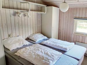 Rødhusにある6 person holiday home in Pandrupの壁のある部屋にベッド2台が備わります。