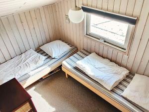 two beds in a room with a window at 6 person holiday home in Pandrup in Rødhus