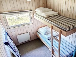 a small room with two bunk beds and a window at 6 person holiday home in Pandrup in Rødhus