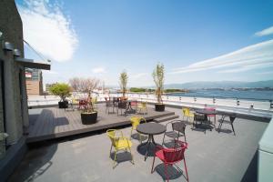 a patio with tables and chairs with a view of the water at HakoBA Hakodate by THE SHARE HOTELS in Hakodate