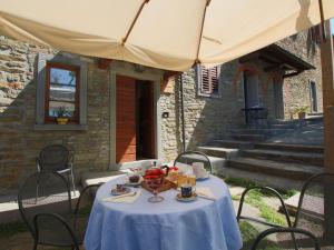 a table with a bowl of food on it under an umbrella at Farmhouse in Campriano in Chiassa Superiore