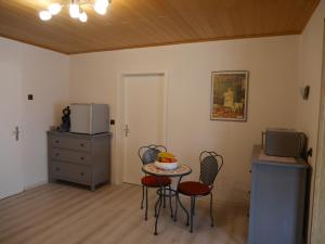 Habitación pequeña con mesa, sillas y microondas. en Wäller Ruh', en Pfuhl