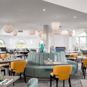 哈文特的住宿－Langstone Quays Resort，餐厅设有绿色的沙发和桌椅
