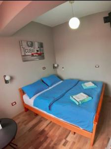 Un dormitorio con una cama con sábanas azules y almohadas azules. en Elisabet Tirana, en Tirana