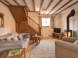 a living room with two couches and a fireplace at Boddingtons Barn @ Norton Grounds in Chipping Campden