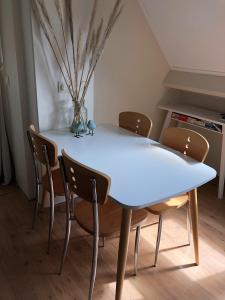 a white dining table and chairs in a room at Apartment Zonnehoek in Aagtekerke
