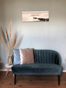 a green couch in a living room with a painting at Apartment Zonnehoek in Aagtekerke