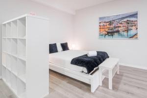 a white bedroom with a bed and a desk at Oporto Downtown View Apartment in Porto