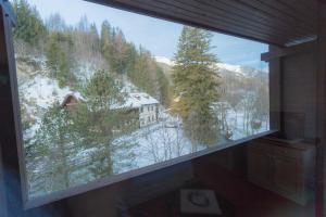 a large window in a bathroom with a view of a house at Hotel Neuwirt in Mauterndorf