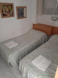 two twin beds in a small room with at Moby dick 1D (Verblijf aan de costa) in Benidorm