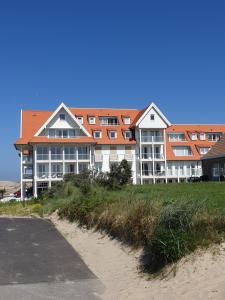 a large building on top of a sandy beach at Penthouse Windkracht 10 aan het strand van Cadzand in Cadzand