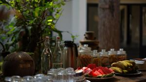 a table topped with plates of fruit and bottles at Stop and Go Boutique Hotel in Da Lat