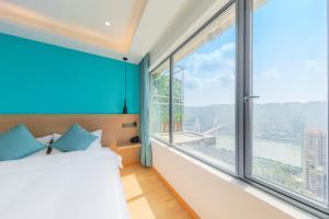 a bedroom with a bed and a large window at Yunqi River View Terrace Hotel in Chongqing