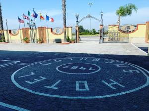 a clock on the ground in front of a roller coaster at Hotel Smeraldo in Qualiano