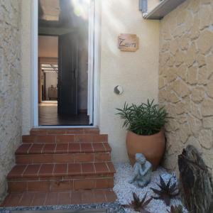 a stairway with a plant in a pot next to a door at La Picholine in Sorède +16 photos
