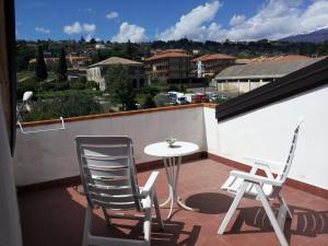 un patio con 2 sillas y una mesa en el balcón en B&B Suite, en Viagrande