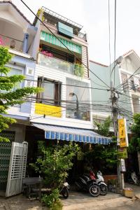 a building with a blue awning and motorcycles parked in front at Homestay Xì Trum in Danang