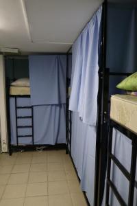 モスクワにあるTravel Inn Timiryazevskayaの二段ベッド2台、青いカーテンが備わる客室です。