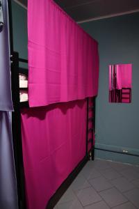 モスクワにあるTravel Inn Timiryazevskayaのピンクのカーテンが壁に掛けられた部屋