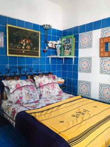 1 dormitorio con 1 cama con paredes de azulejos azules en The 18, Marsa Guest House, en La Marsa