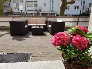 a group of chairs and flowers on a patio at Hotel Post in Kelkheim