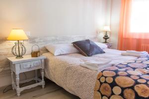 1 dormitorio con 1 cama y 1 mesa con lámpara en Atico de Pollo Martin, en Salamanca