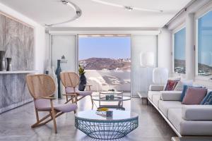 a living room with a couch and a table at Myconian Kyma - Design Hotels in Mikonos