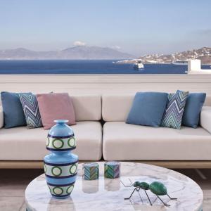 a living room with a couch and a table with two bugs at Myconian Kyma, a Member of Design Hotels in Mýkonos City