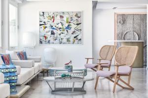 uma sala de estar com um sofá e cadeiras e um quadro em Myconian Kyma, a Member of Design Hotels em Míconos