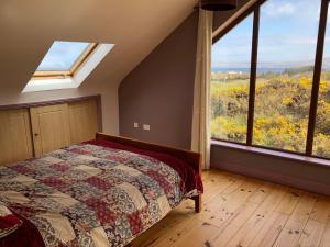
a bedroom with a bed and a window at House with sea views close to Beach with WiFi and large kitchen and dining in Ardnagreevagh
