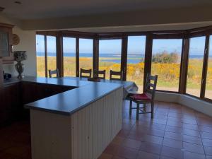 
a kitchen with a table and chairs and a window at House with sea views close to Beach with WiFi and large kitchen and dining in Ardnagreevagh
