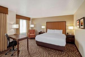 
a hotel room with a bed and a chair at La Quinta by Wyndham Las Vegas RedRock/Summerlin in Las Vegas
