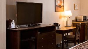 a hotel room with a large television on a desk at High Country Inn in Banff